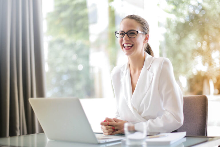 laughing woman at desk with laptop