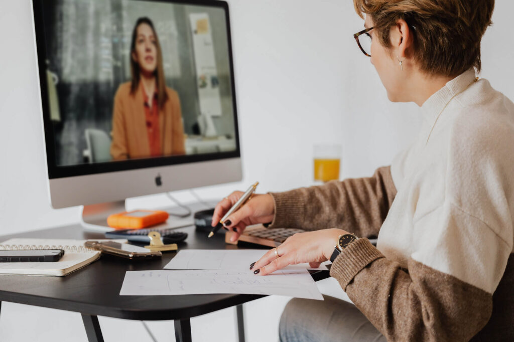 woman at desk receiving training in a virtual meeting