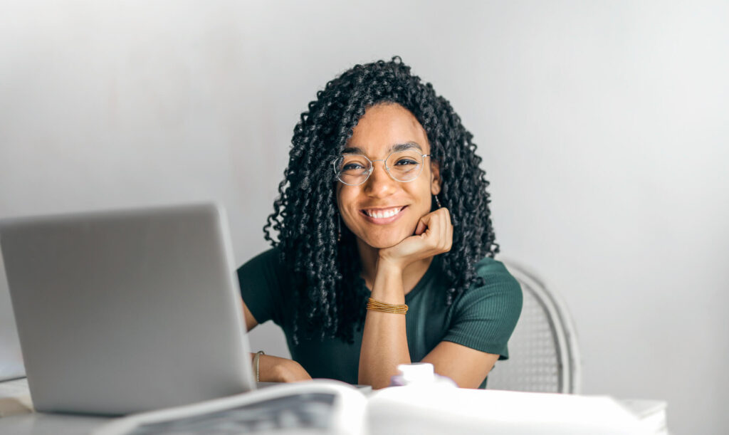 happy woman sitting at table with laptop